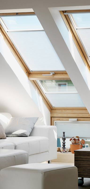 Innenraumszene mit VELUX GPL Klapp-Schwingfenstern, Erweiterung LICHTBAND und Fassadenanschluss-Fenstern in Holz Kiefer natur